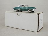 une petite voiture verte posée sur une boîte
