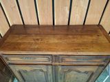 a wooden cabinet with two doors and a drawer underneath it