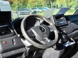 a steering wheel and dashboard of a vehicle with a laptop on the dashboard