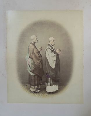 une vieille photo montrant deux hommes en costume traditionnel, debout l'un à côté de l'autre