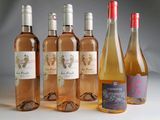plusieurs bouteilles de vin sont alignées sur une surface blanche