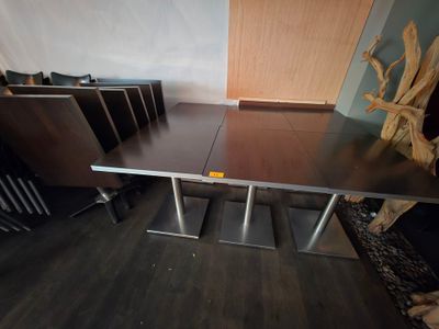 des tables et des chaises dans une pièce avec un parquet et un mur