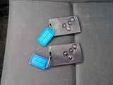 two keys that are attached to the seat belt of a car