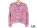 un cardigan rose sur un cintre, sur fond blanc