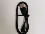 a close up of a black usb cable connected to a white wall