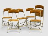 four chairs are lined up in a row on a white surface