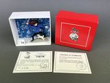 a box with a dog figurine in it sitting next to a card