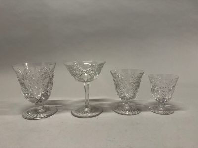 quatre verres à pied sont alignés sur une surface blanche