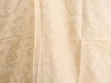 a cat that is sitting on the floor next to a curtain