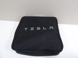 black bag with tesla logo on it sitting on a white surface