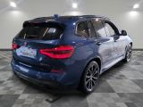 the rear end of a blue bmw suv parked on a checkered floor