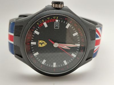une montre noire ornée d'un bracelet rouge, blanc et bleu