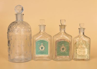 Des bouteilles de différentes tailles et formes sont alignées sur une table.