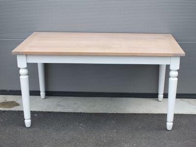 une photo d'une table blanche avec un plateau en bois posée sur un trottoir