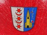 a red suitcase with a coat of arms on it