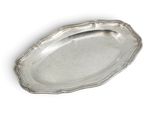 an oval silver tray with a scalloped edge on a white background