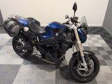 une moto bleue garée sur un sol à damier