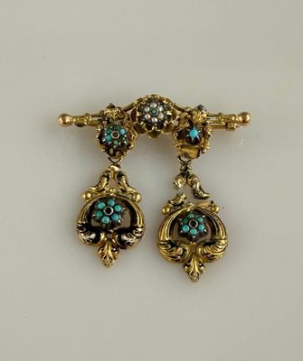 paire de boucles d'oreilles dorées ornées de pierres turquoise sur fond blanc