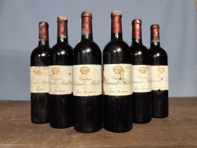 six bottles of wine are lined up on a wooden table