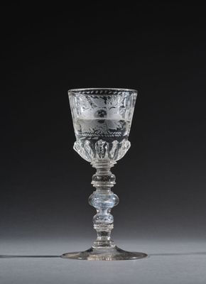 glass goblet in the shape of a cup with a design of flowers and leaves