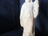 une statue blanche représentant un ange sur fond noir