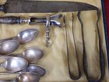 de nombreuses cuillères et couteaux-cuillères en argent dans un coffret
