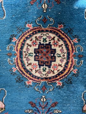 a close up of a blue rug with a medallion design on it