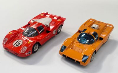 deux voitures jouets assises l'une à côté de l'autre sur une surface blanche