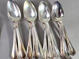five spoons that are sitting on a table