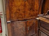 a wooden cabinet and a chair in a room