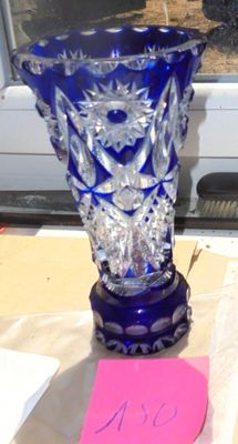 a blue glass vase sitting on a table next to a window