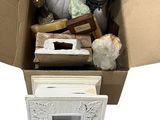 une boîte en carton remplie d'objets divers posée sur une surface blanche