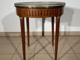 a small table with a glass top on a tiled floor