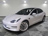 the white tesla model 3 is parked on a checkered floor