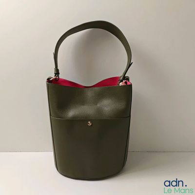 Le petit sac vert est muni d'une poignée rouge.