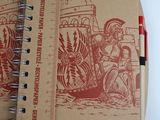 a brown notebook with a red pen on top of it
