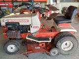a picture of a red riding lawn mower parked in a garage