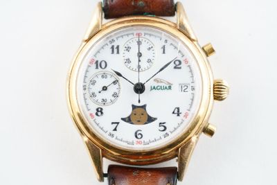 une montre en or avec un cadran blanc et un bracelet en cuir marron