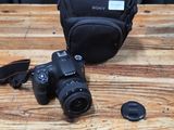 a camera and a bag on a wooden table