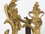 a gold sculpture of a bird and a vase on a stand