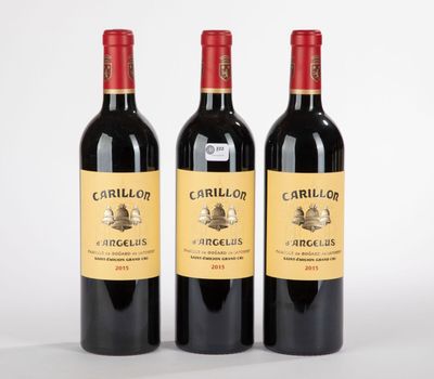 trois bouteilles de vin rouge posées l'une à côté de l'autre sur une surface blanche