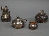 quatre couverts posés sur une table devant un fond gris