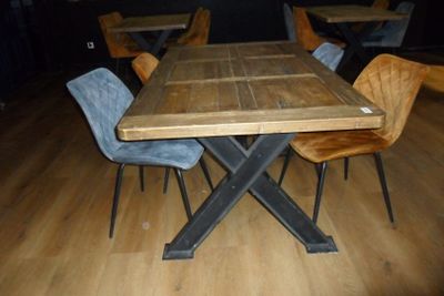 une table et des chaises en bois dans une pièce avec un parquet