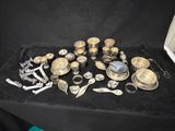 an assortment of silverware on a table with a black cloth