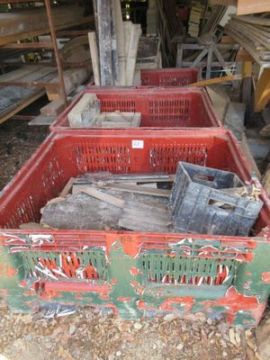 Plusieurs caisses en bois sont empilées dans un local de stockage