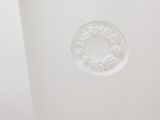 a white vase that has a circular design on it
