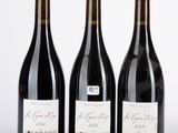 trois bouteilles de vin posées l'une à côté de l'autre sur une table