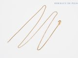 a pair of gold necklaces on a white background