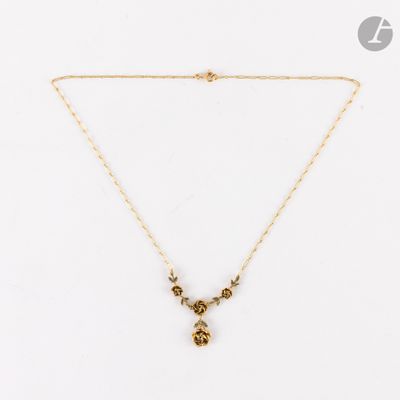 un collier en or avec un pendentif en forme de fleur, monté sur une chaîne en or