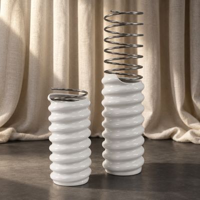 deux vases blancs contenant des branches de printemps, posés sur une table